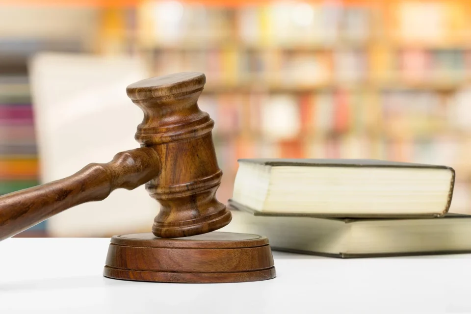 Mazo de juez y libros de Derecho civil sobre mesa de madera.